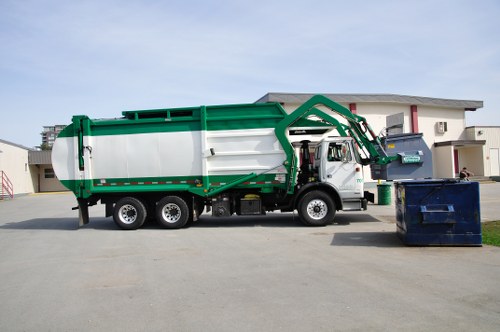 Crew loading a skip at a commercial site with safety gear visible